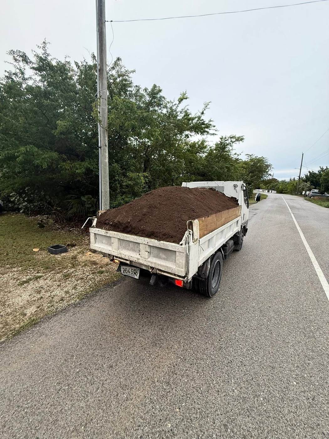Rivers Landscaping truck hauling soil along a Grand Cayman road