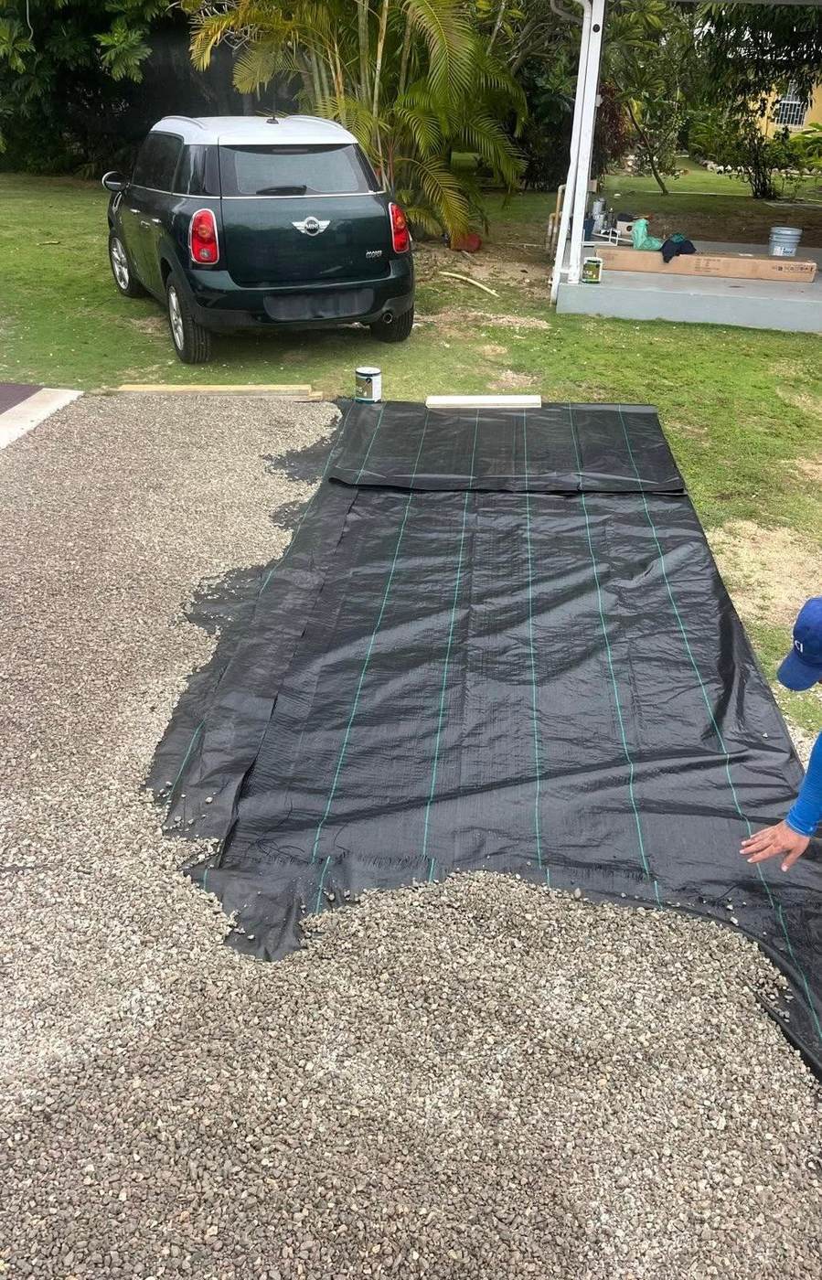 Weed barrier fabric being installed under a gravel driveway